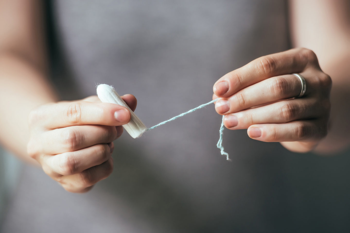 Young woman hands holding hygienic tampon